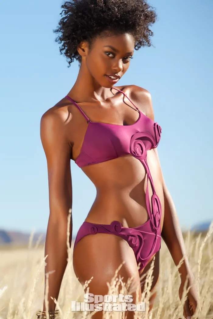 Adaora poses in a pink bikini in the tall grass.